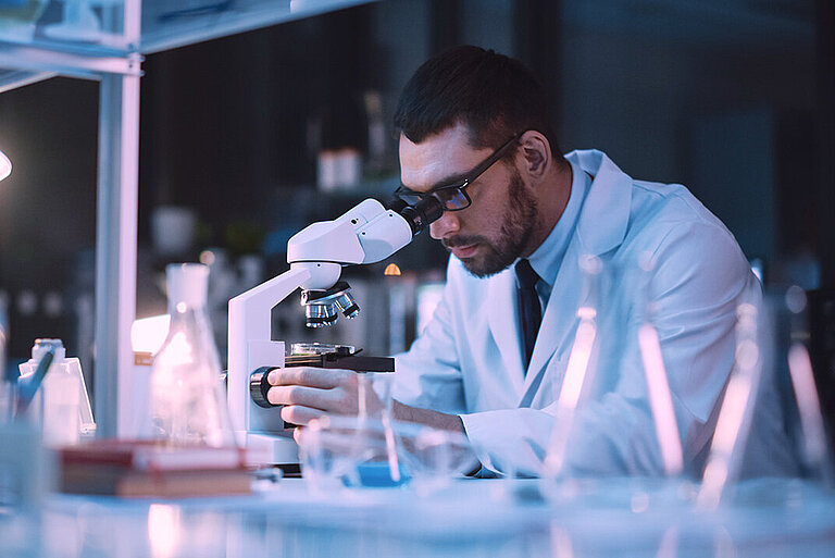 Forschung & Entwicklung Mann an einem Mikroskop