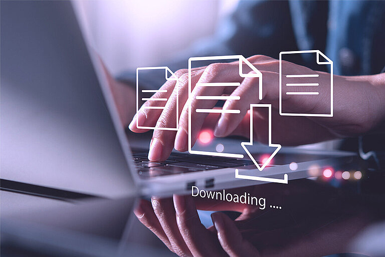 Download von Datenblättern, Broschüren, Zertifikaten menschliche Hand über einer Laptoptastatur, im Vordergrund schweben Download-Icons