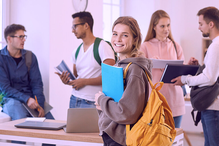 Ausbildung bei Raesch Quarz Lächelnde Frau mit Rucksack und Buch