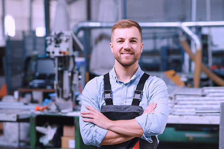 Arbeiten bei dem Experten für Quarzglas Mann in Arbeitshosen in einer Fabrikhalle
